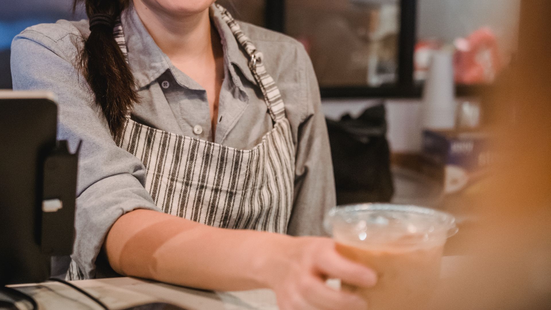 Barista at the counter with a tablet till