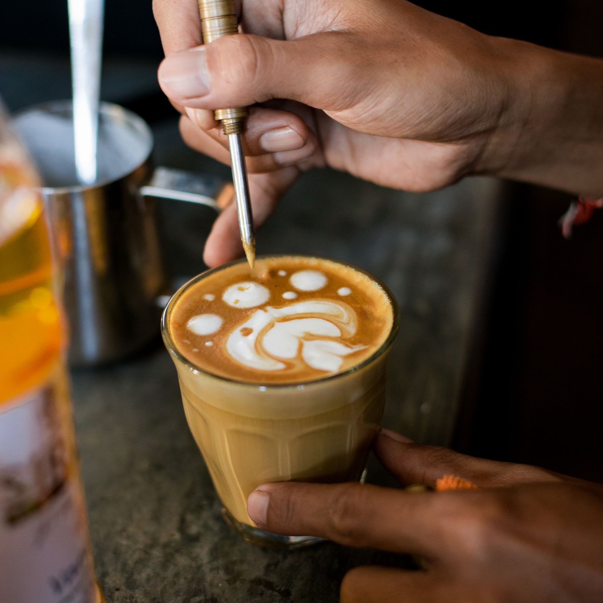 Barista etching latte art into a glass