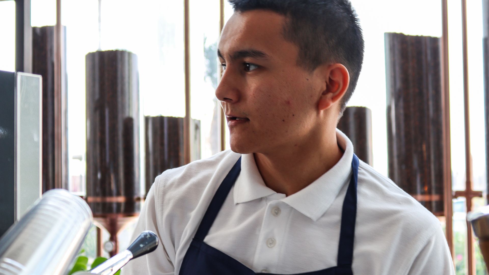 Barista in an apron by the café window