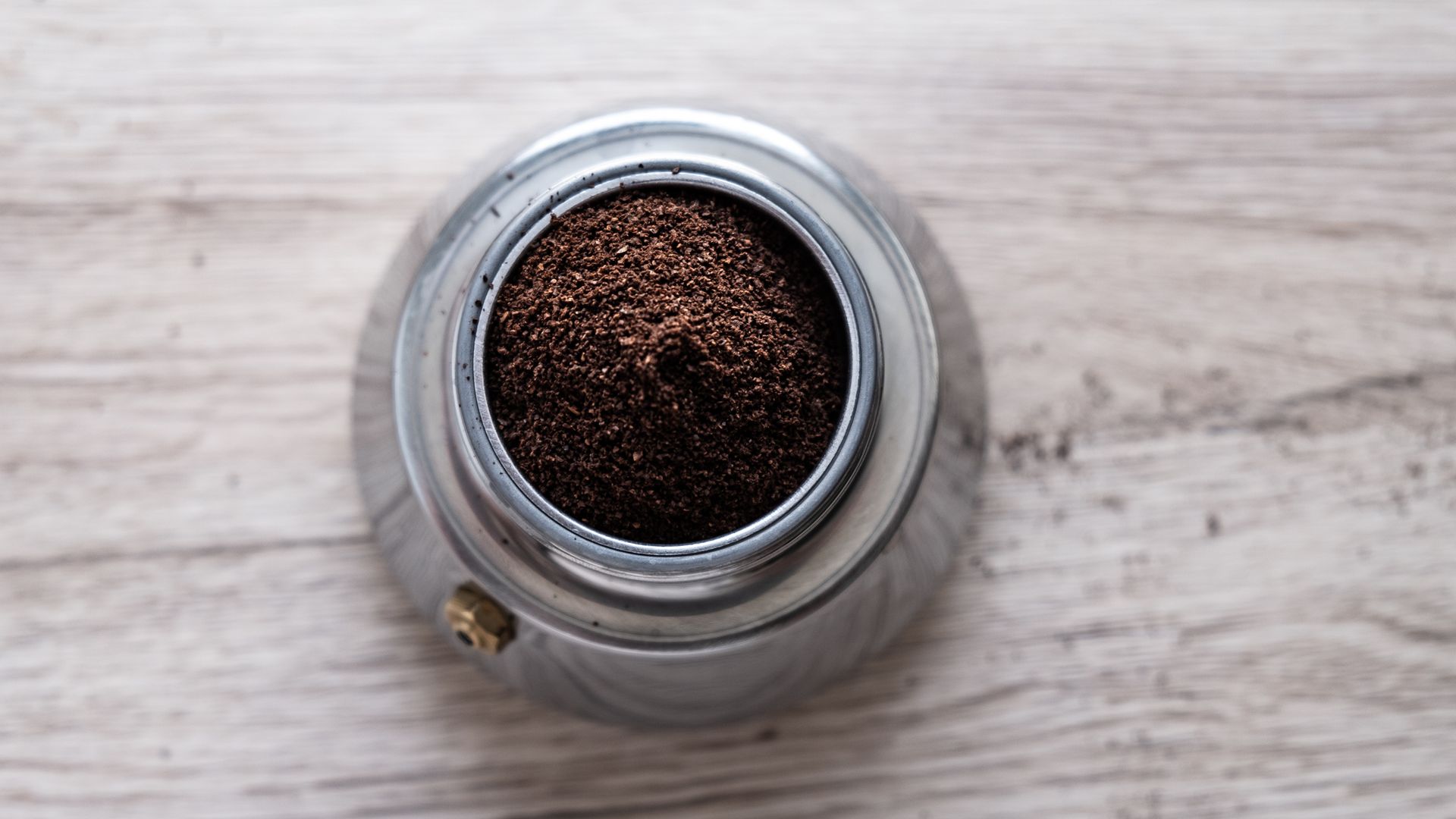 Moka pot filled with fresh coffee grounds, top down