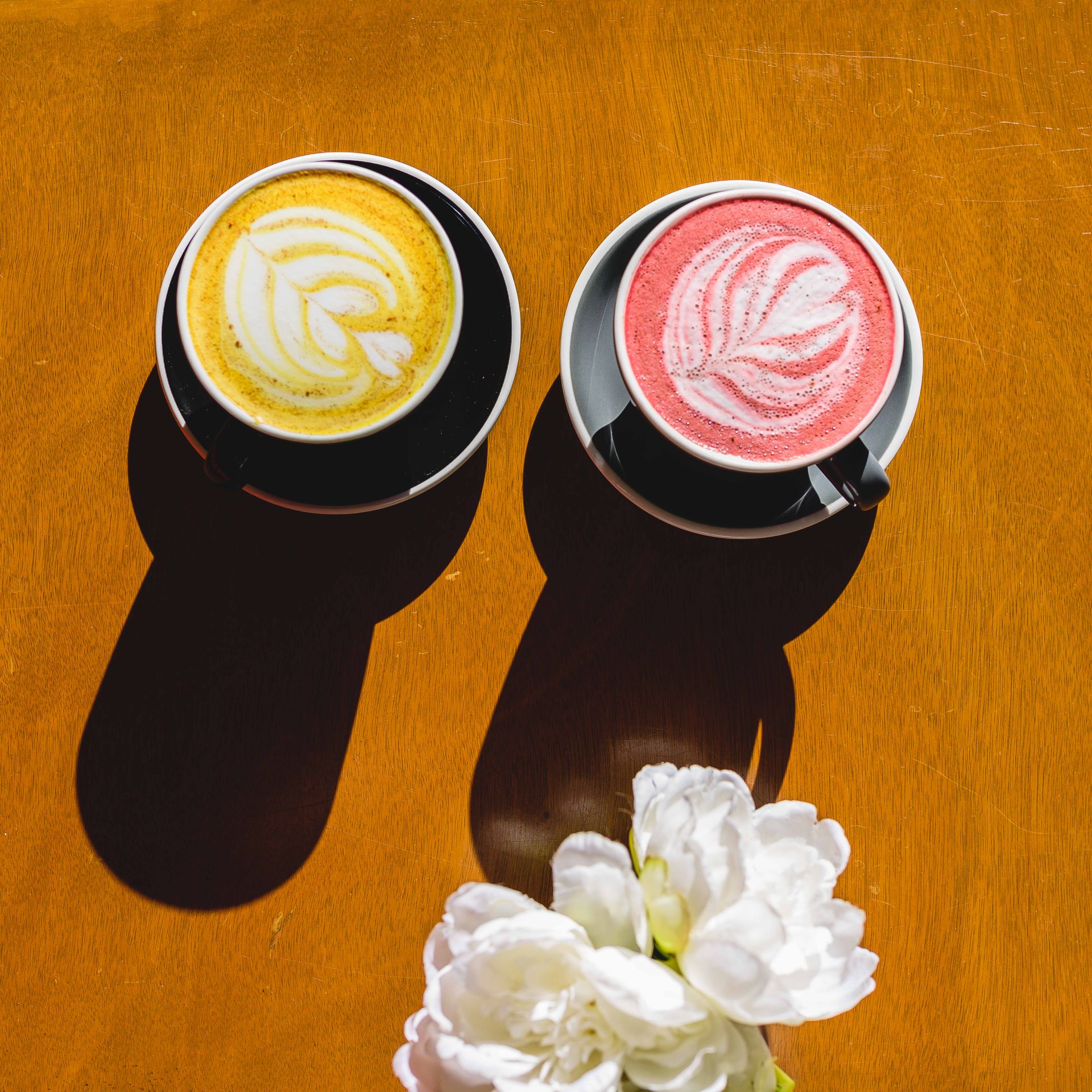 Two speciality lattes on warm wood